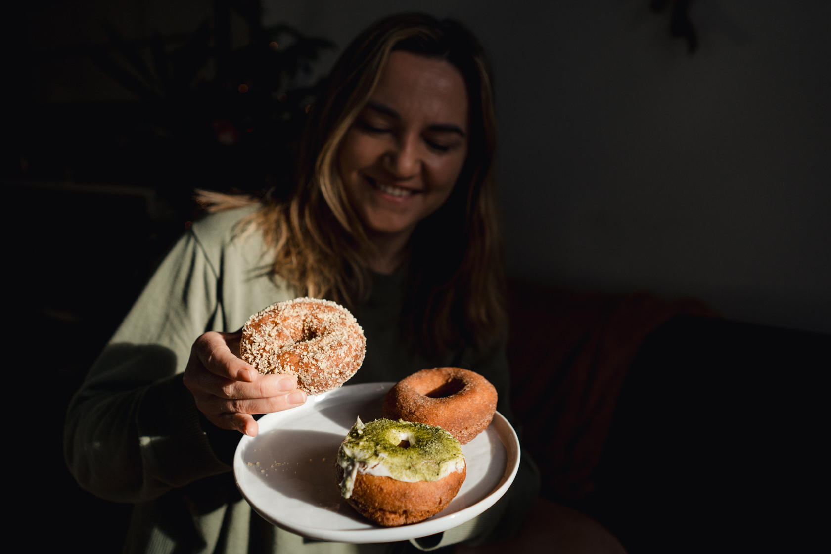 woman holding three doughnuts from Lee's Donuts in Vancouver