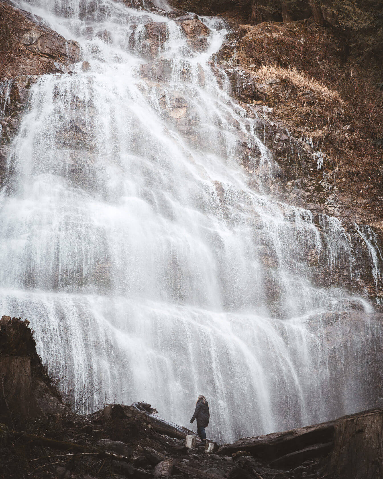 hiker standing at the base of Bridal Veil Falls waterfall in Chilliwack