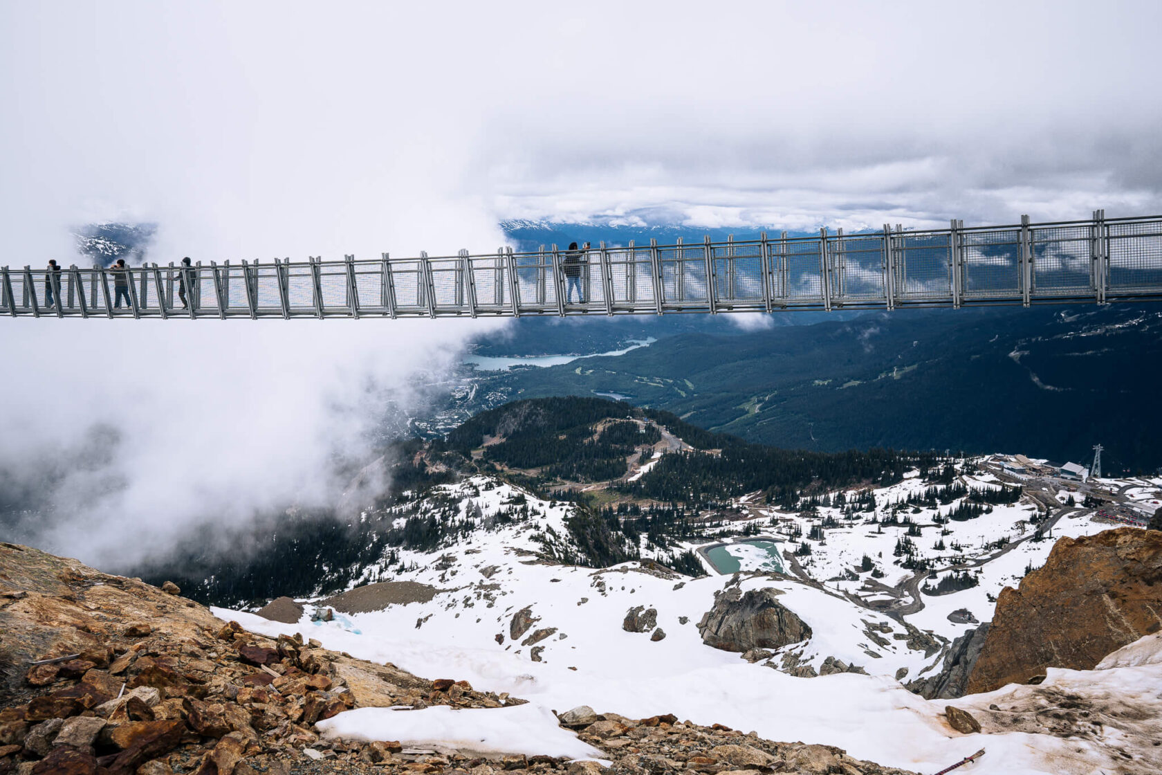 people high up on the suspension bridge on Whistler Mountain partly covered in the clouds