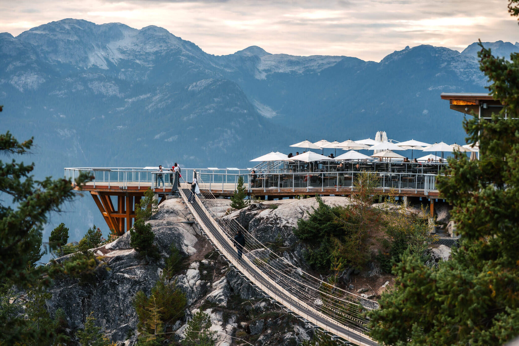 Sun deck and suspension bridge with mountains in the background viewed from the Sea to Sky highway