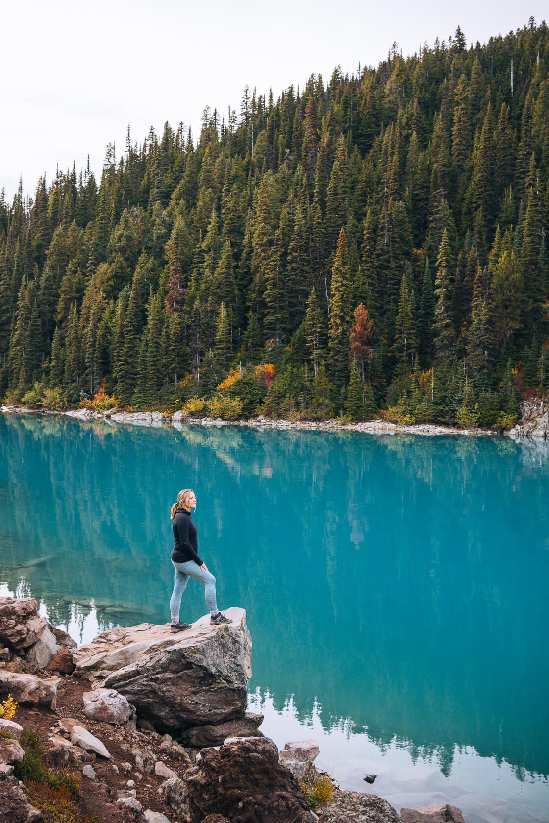 female hiker standing by incredibly blue Garibaldi Lake