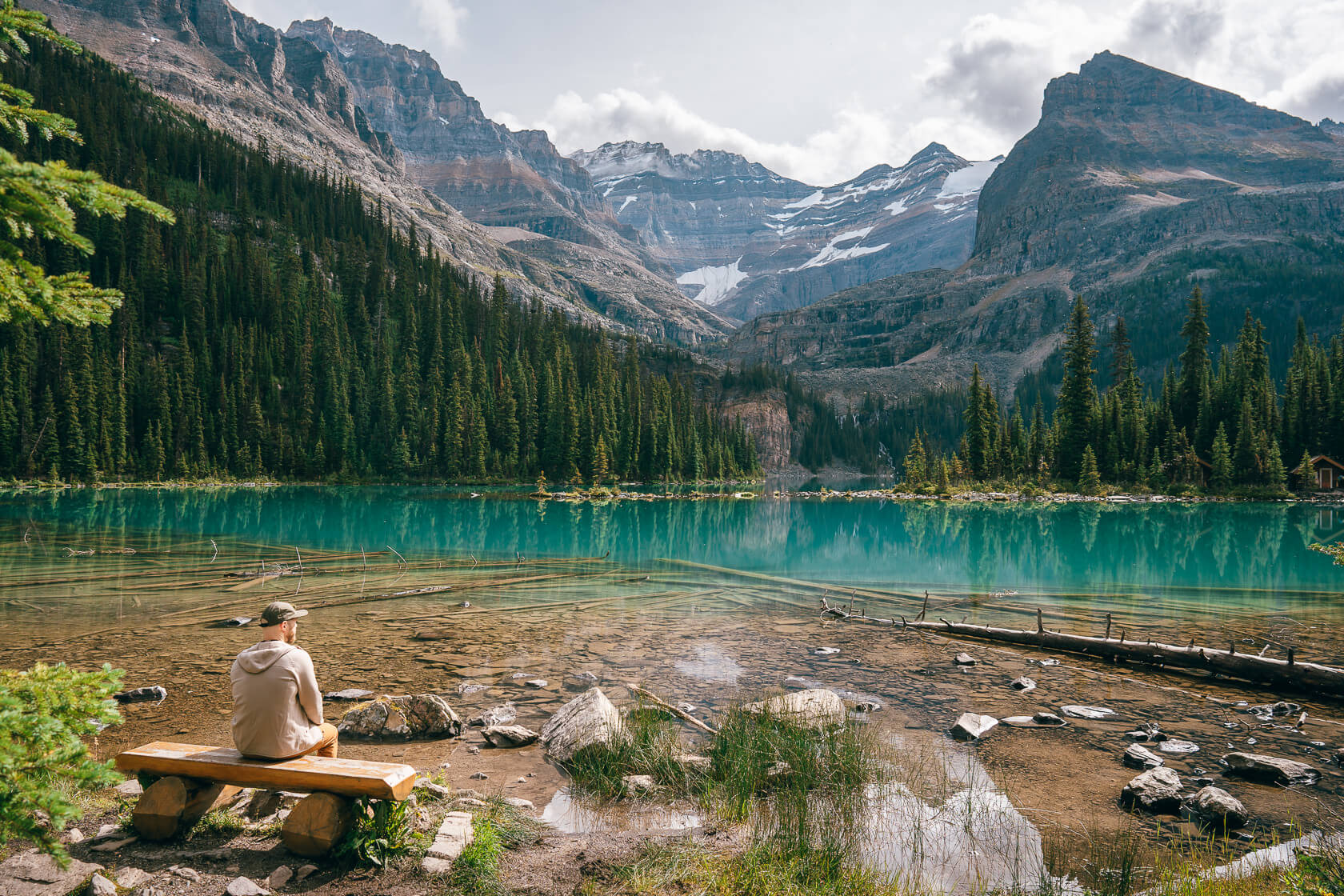 Hiker sitting on the bench at the shore of Lake O'Hara 